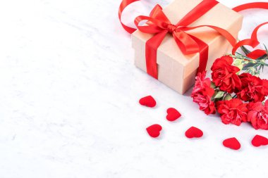 Mayıs anneler gün kavramı el yapımı giftbox fikir Fotoğrafçılık dilek-modern mermer masada izole kırmızı şerit yay kutusu ile güzel çiçeklenme karanfil, yakın çekim, kopya alanı, alay