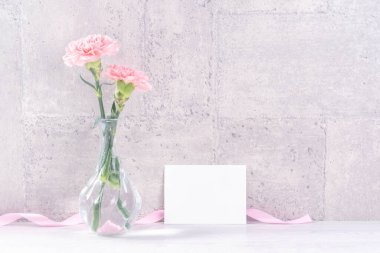 Anneler günü hediye kutusu sürprizi fotoğrafçılığı ister - Gri duvar kağıdı tasarımında izole edilmiş pembe kurdele kutulu güzel karanfiller, kapat, kopyala, taklit et