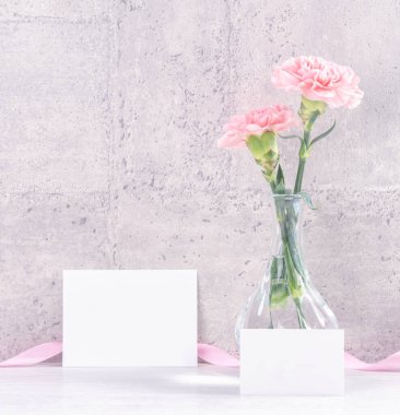 Anneler günü hediye kutusu sürprizi fotoğrafçılığı ister - Gri duvar kağıdı tasarımında izole edilmiş pembe kurdele kutulu güzel karanfiller, kapat, kopyala, taklit et