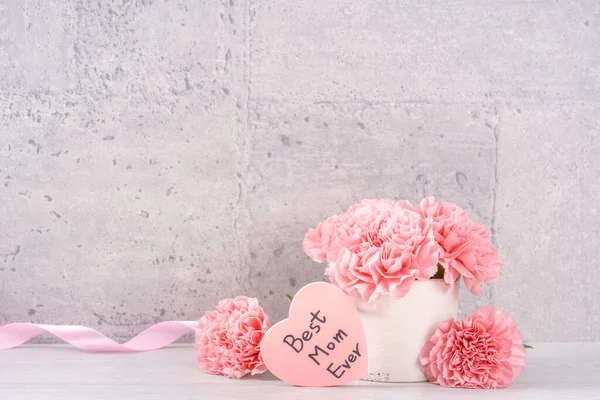 stock image Mothers day handmade giftbox surprise wishes photography - Beautiful blooming carnations with pink ribbon box isolated on gray wallpaper design, close up, copy space