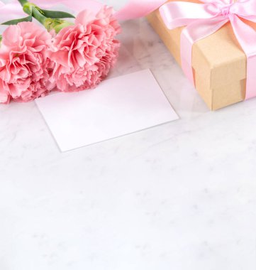 Anneler günü el yapımı hediye kutusu fikri, bebek pembe kurdeleli güzel karanfiller modern mermer masaya izole edilmiş, kapatın, kopyalayın, taklit edin