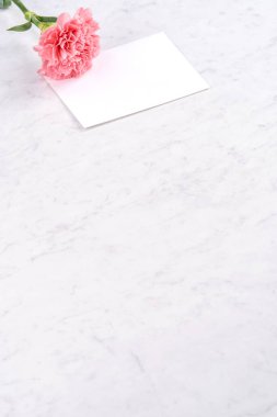 Anneler günü el yapımı hediye kutusu fikri, bebek pembe kurdeleli güzel karanfiller modern mermer masaya izole edilmiş, kapatın, kopyalayın, taklit edin