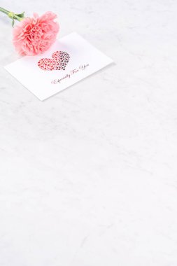 Anneler günü el yapımı hediye kutusu fikri, bebek pembe kurdeleli güzel karanfiller modern mermer masaya izole edilmiş, kapatın, kopyalayın, taklit edin