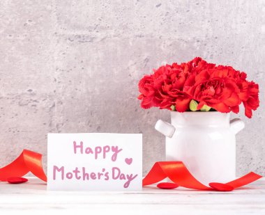Mayıs Anneler Günü el yapımı giftbox tasarım fotoğraf - dilek güzel çiçek açan karanfil gri, ahşap arka plandaki tabloda, izole vazoda yakın çekim, uzay kopyalamak, yukarı alay