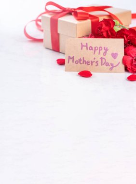 El yapımı giftbox fotoğrafçılık - modern mermer masasında izole kırmızı şerit yay kutusuyla güzel çiçek açan karanfil dilek Mayıs Anneler günü yakın çekim, uzay kopyalayın, yukarı alay