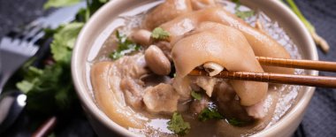 Üstte görünüm, yakın çekim, kopya alanı, Tayvan Asya ayırt edici sokak gıda, bej Fildişi krem-beyaz renkli kase koyu Shale arduvaz masada izole fıstık domuz knuckle çorba