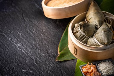 Yakın çekim, kopya alanı, Dragon Boat (Duan Wu) festivalinde ünlü Asya lezzetli el yapımı gıda, buharda buharda pirinç köfte şeklinde piramit yaprakları malzemeler tarafından sarılmış taze