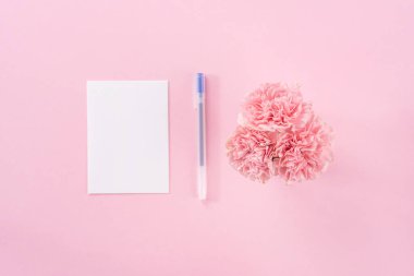 Üst görünüm, düz yatıyordu, mock up, kopya alanı, el yazısı tebrik kartı şablon soluk pembe arka plan ile izole, teşekkür fikir kavramı, dilek, zanaat karanfil buket