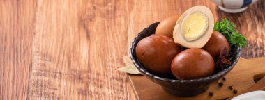 Lezzetli geleneksel Tayvan çay yumurtalarını ahşap masa arkasında bir kaseyle kapat..