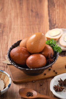 Lezzetli geleneksel Tayvan çay yumurtalarını ahşap masa arkasında bir kaseyle kapat..