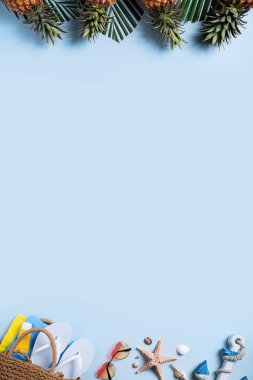 Yaz meyvesi tasarımı konsepti. Deniz kabukları, şapka, ananas ve mavi arka planda palmiye yapraklarıyla tatil gezilerinin en üst manzarası..