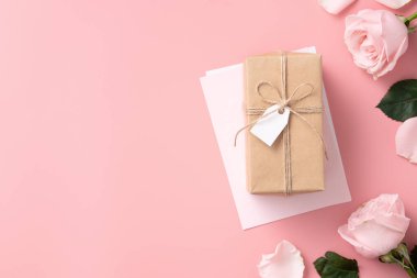 Pembe gül çiçekli Anneler Günü tasarım konsepti ve pembe masa arkasında paketlenmiş Kraft hediye kutusu..