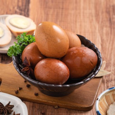 Lezzetli geleneksel Tayvan çay yumurtalarını ahşap masa arkasında bir kaseyle kapat..
