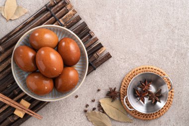 Lezzetli geleneksel Tayvan çay yumurtalarının üst görüntüsü. Gri masa arka planında bir kasede..
