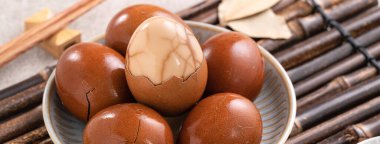 Lezzetli geleneksel Tayvan çay yumurtalarını kapayın, arka planda gri bir kaseyle..