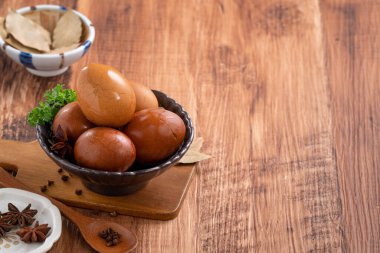 Lezzetli geleneksel Tayvan çay yumurtalarını ahşap masa arkasında bir kaseyle kapat..
