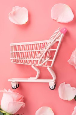 Anneler Günü alışveriş tasarımı konsepti pembe gül çiçeği ve el arabası arka planda.