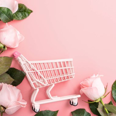 Anneler Günü alışveriş tasarımı konsepti pembe gül çiçeği ve el arabası arka planda.