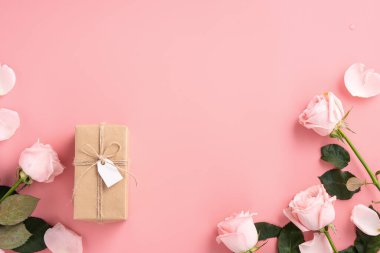 Pembe gül çiçekli Anneler Günü tasarım konsepti ve pembe masa arkasında paketlenmiş Kraft hediye kutusu..