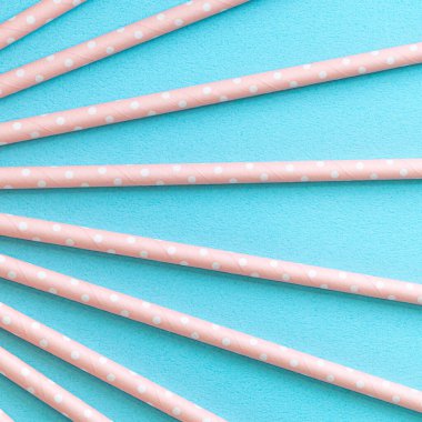 Mavi masa arka planında, biyolojik olarak çözünebilen, benekli, pembe kamış seti. Dünya Günü için çevre koruma kavramı..