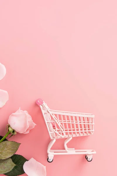 ピンクのバラの花とピンクのテーブルの背景にカートと母の日のショッピングデザインのコンセプトの背景 — ストック写真