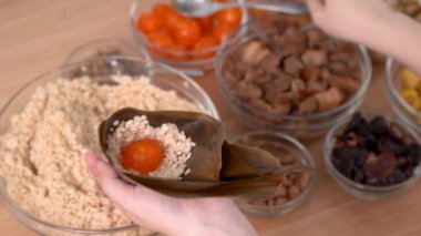Zongzi yemeği yapmak - Duanwu Ejder Teknesi Festivali için evde Çin pirinçli börek hazırlamak ve paketlemek, yaşam tarzı.