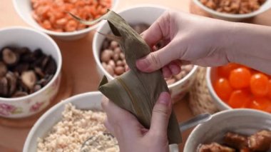 Zongzi yemeği yapmak - Duanwu Ejder Teknesi Festivali için evde Çin pirinçli börek hazırlamak ve paketlemek, yaşam tarzı.