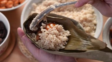 Zongzi yemeği yapmak - Duanwu Ejder Teknesi Festivali için evde Çin pirinçli börek hazırlamak ve paketlemek, yaşam tarzı.