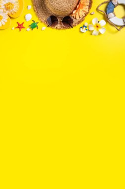 Yaz sahili tasarımı konsepti. Deniz kabukları, şapka, sarı arka planda terlik ile tatil seyahatinin en üst görüntüsü.