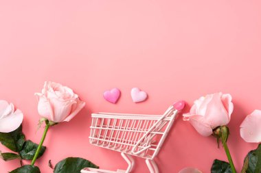 Anneler Günü alışveriş tasarımı konsepti pembe gül çiçeği ve el arabası arka planda.