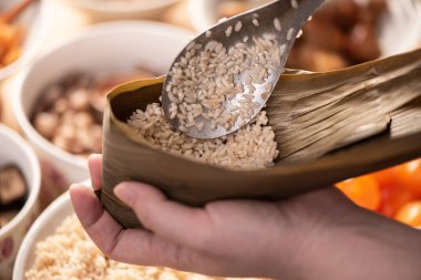 Zongzi yemeği yapmak - Duanwu Ejder Teknesi Festivali için evde Çin pirinçli börek hazırlamak ve paketlemek, yaşam tarzı.