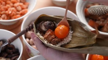 Zongzi yemeği yapmak - Duanwu Ejder Teknesi Festivali için evde Çin pirinçli börek hazırlamak ve paketlemek, yaşam tarzı.
