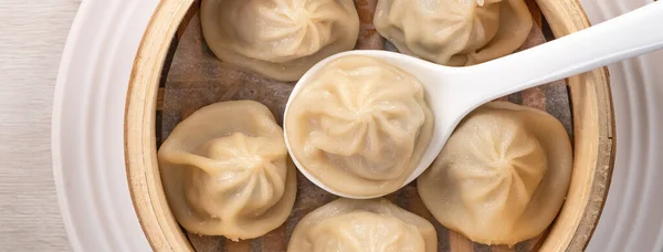 Eating steamed pork soup dumplings named Xiao long bao xiaolongbao in Taiwan, Taiwanese famous gourmet.