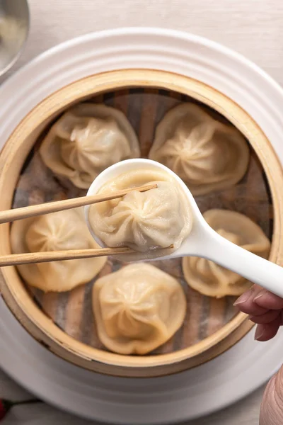 Eating steamed pork soup dumplings named Xiao long bao xiaolongbao in Taiwan, Taiwanese famous gourmet.