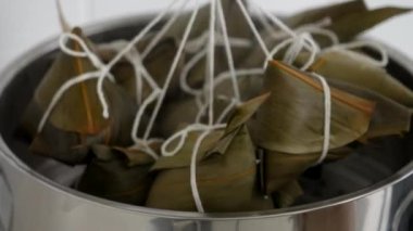 Zongzi yemeği pişirmek - Duanwu Ejder Teknesi Festivali için evde Çin pirinçli börek hazırlamak ve pişirmek, yaşam tarzı.