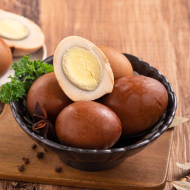 Lezzetli geleneksel Tayvan çay yumurtalarını ahşap masa arkasında bir kaseyle kapat..