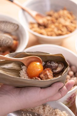 Zongzi yemeği yapmak - Duanwu Ejder Teknesi Festivali için evde Çin pirinçli börek hazırlamak ve paketlemek, yaşam tarzı.