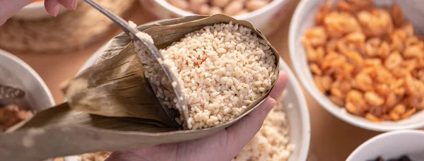 Making zongzi food - preparing and wrapping Chinese rice dumpling at home for Duanwu Dragon Boat Festival celebration, lifestyle.