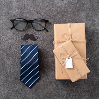 Babalar Günü arka plan tasarımı konsepti. Gri masa arkaplanında hediye kutusu olan kağıt dekorasyonu fikirlerinin üst görünümü.