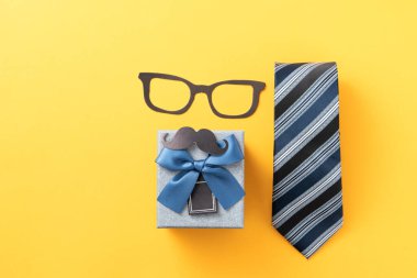 Babalar Günü hediye arkaplan tasarımı konsepti hediye kutusu fikri ve sarı arka planda kravat.