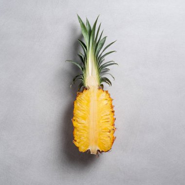 Koyu mavi arka planda tropikal yapraklı taze kesilmiş ananas manzarası.