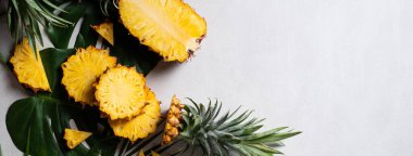 Koyu mavi arka planda tropikal yapraklı taze kesilmiş ananas manzarası.