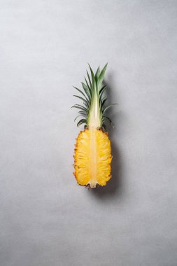 Koyu mavi arka planda tropikal yapraklı taze kesilmiş ananas manzarası.