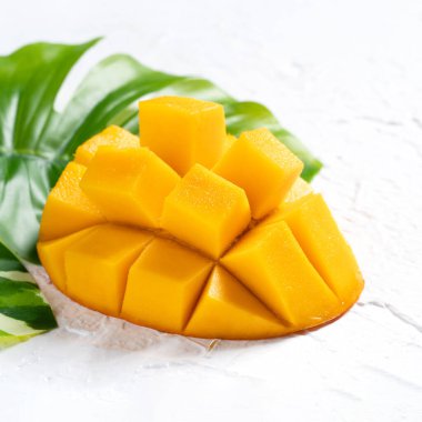 Mango arka plan tasarımı konsepti. Beyaz masa üzerinde yaprakları olan taze mango desenlerinin üst görüntüsü.