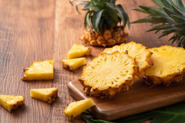 Taze kesilmiş ananasları koyu ahşap masa arkasındaki tepside kapat..