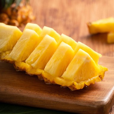 Taze kesilmiş ananasları koyu ahşap masa arkasındaki tepside kapat..