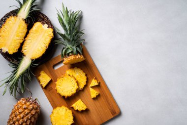 Koyu mavi arka planda tropikal yapraklı taze kesilmiş ananas manzarası.