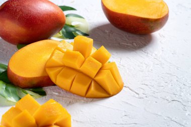 Mango arka plan tasarımı konsepti. Beyaz masa üzerinde yaprakları olan taze mango desenlerinin üst görüntüsü.