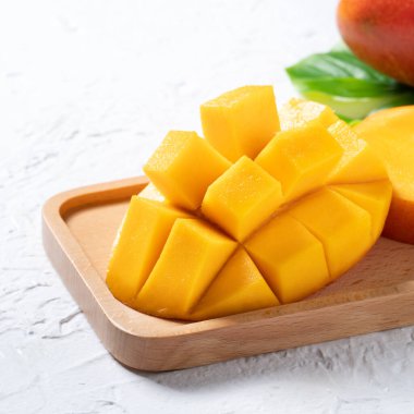 Mango arka plan tasarımı konsepti. Beyaz masa üzerinde yaprakları olan taze mango desenlerinin üst görüntüsü.