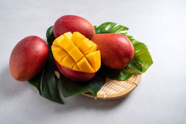 Mango arka plan tasarımı konsepti. Beyaz masa üzerinde yaprakları olan taze mango desenlerinin üst görüntüsü.